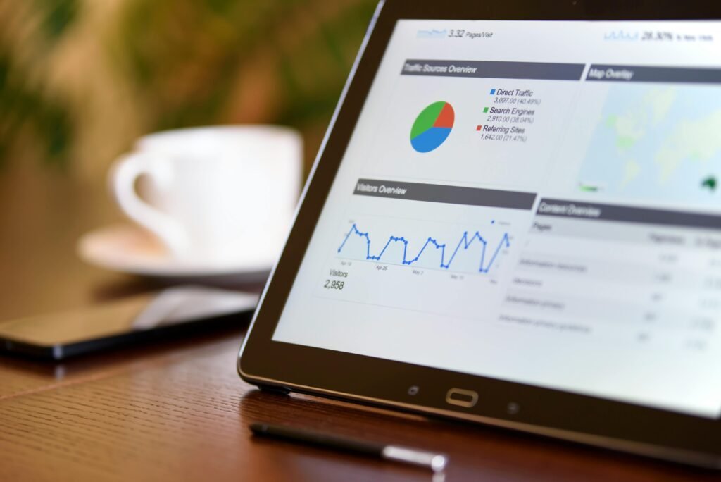 pexels-photo-106344-106344 Close-up of a tablet displaying analytics charts on a wooden office desk, alongside a smartphone and coffee cup.